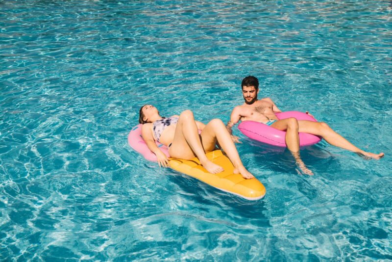 A picture of two people on inflatable tubes hanging out in a pool