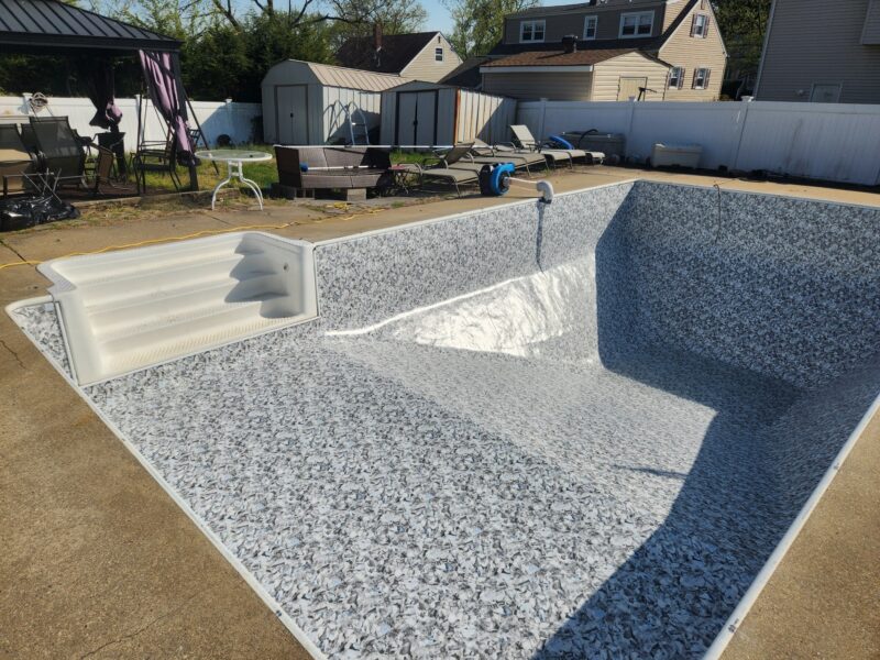 An image of a slate-grey vinyl liner pool without water in the pool