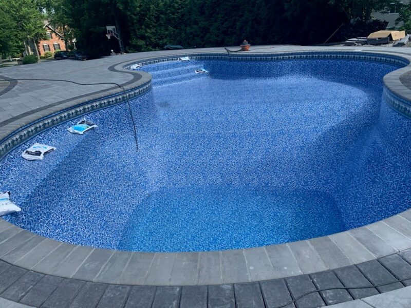 A blue-lined pool in a backyard