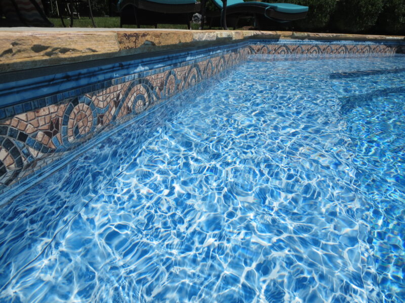 A picure of a pool liner with decorative trim around the edges of the pool